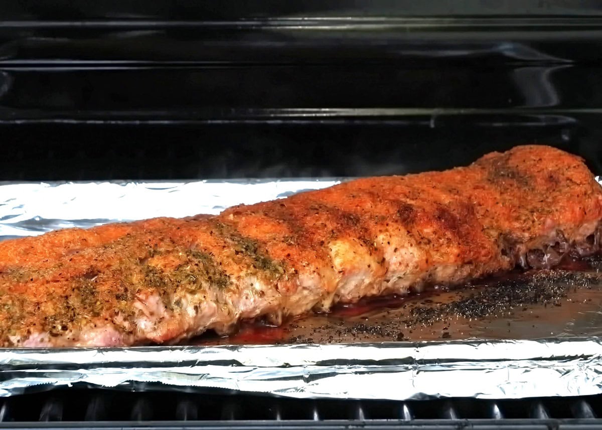 Rack of ribs on a baking sheet in a hot grill.