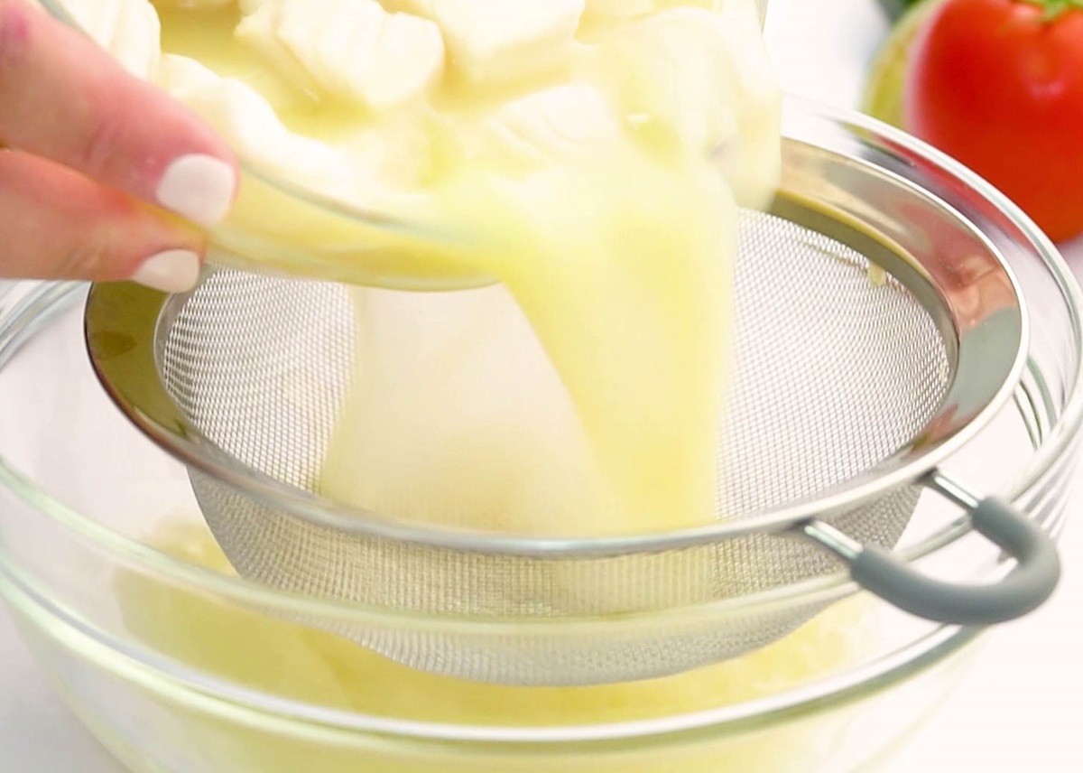 Pouring a bowl of lime juice and fish into a strainer to remove the juice.