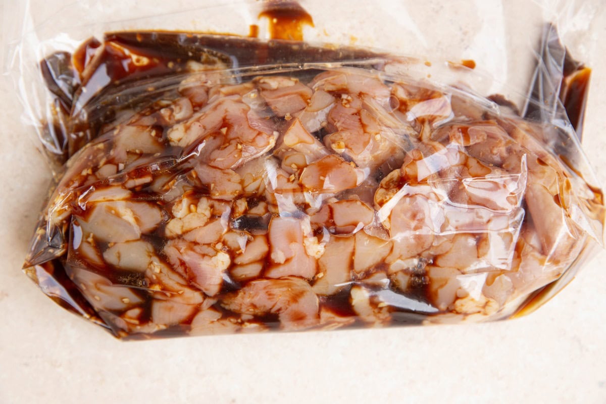 Zip lock bag with chopped chicken pieces in a marinade.