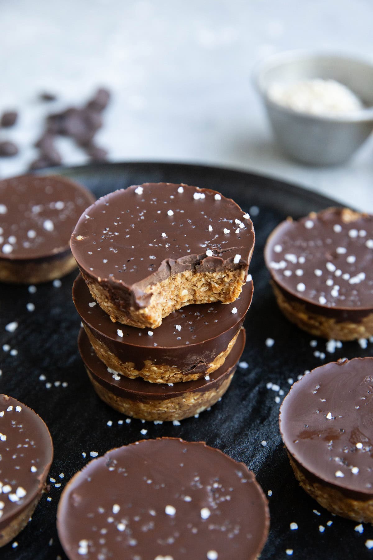 Stack of almond butter cups with the top cup has a bite taken out.