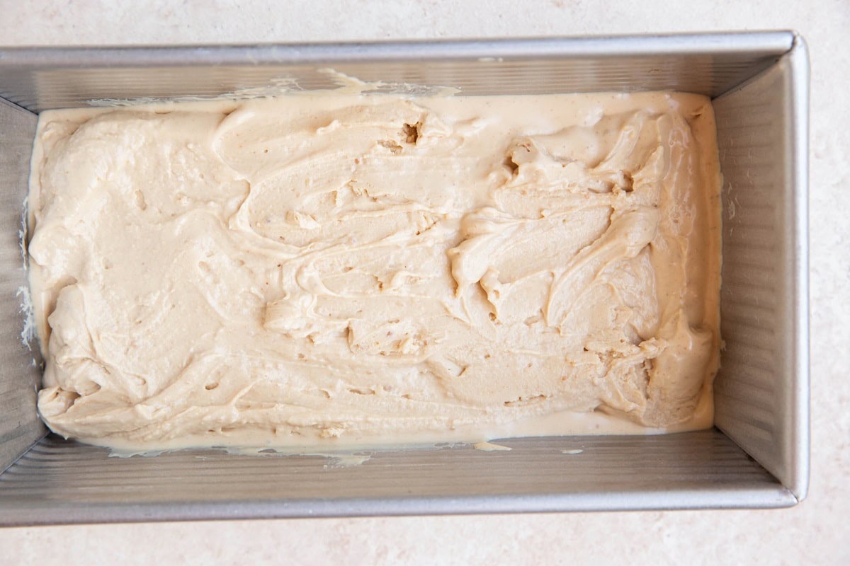 Loaf pan with peanut butter frozen yogurt spread inside.