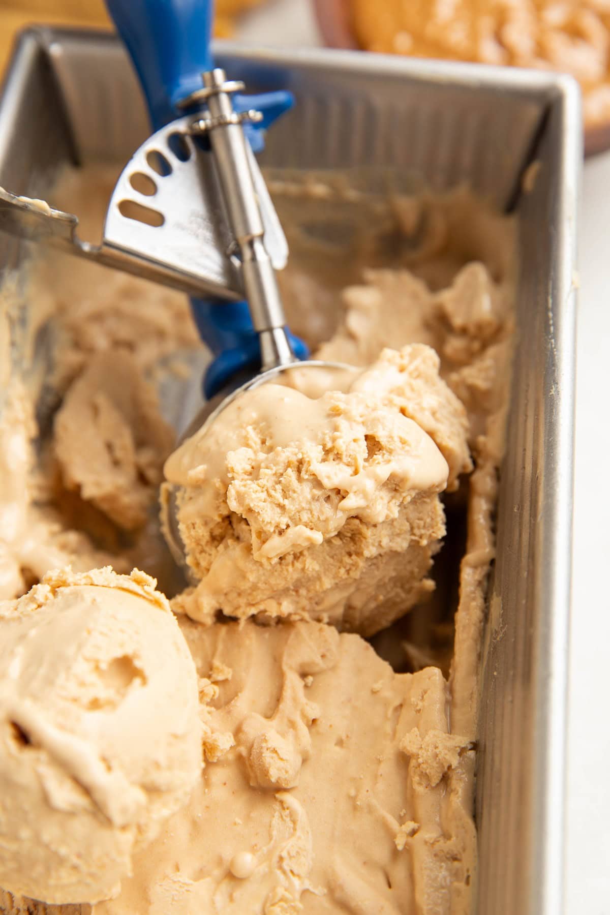 Loaf pan with an ice cream scoop scooping ice cream.