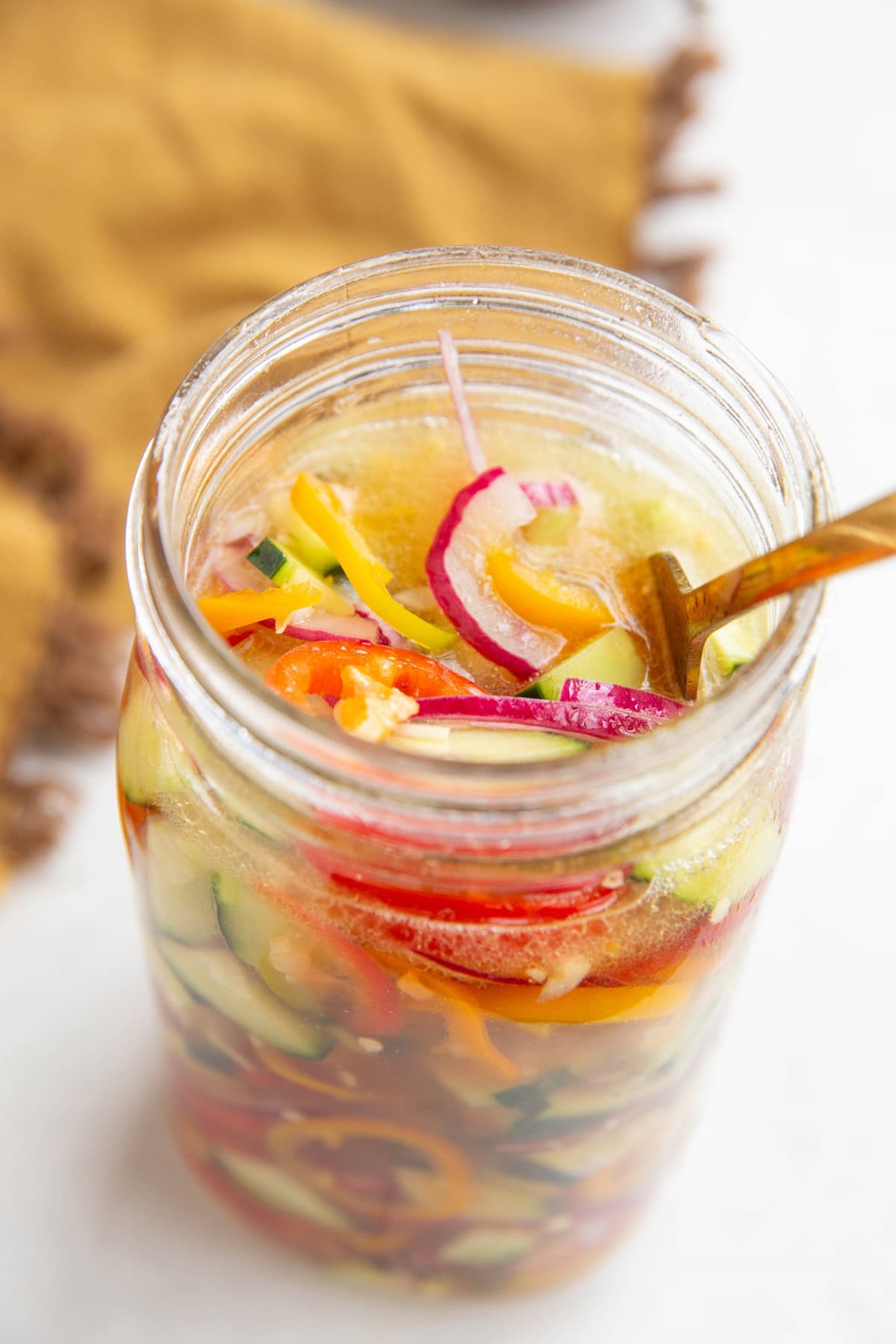 Pickled vegetables in a jar with a fork inside, ready to serve.