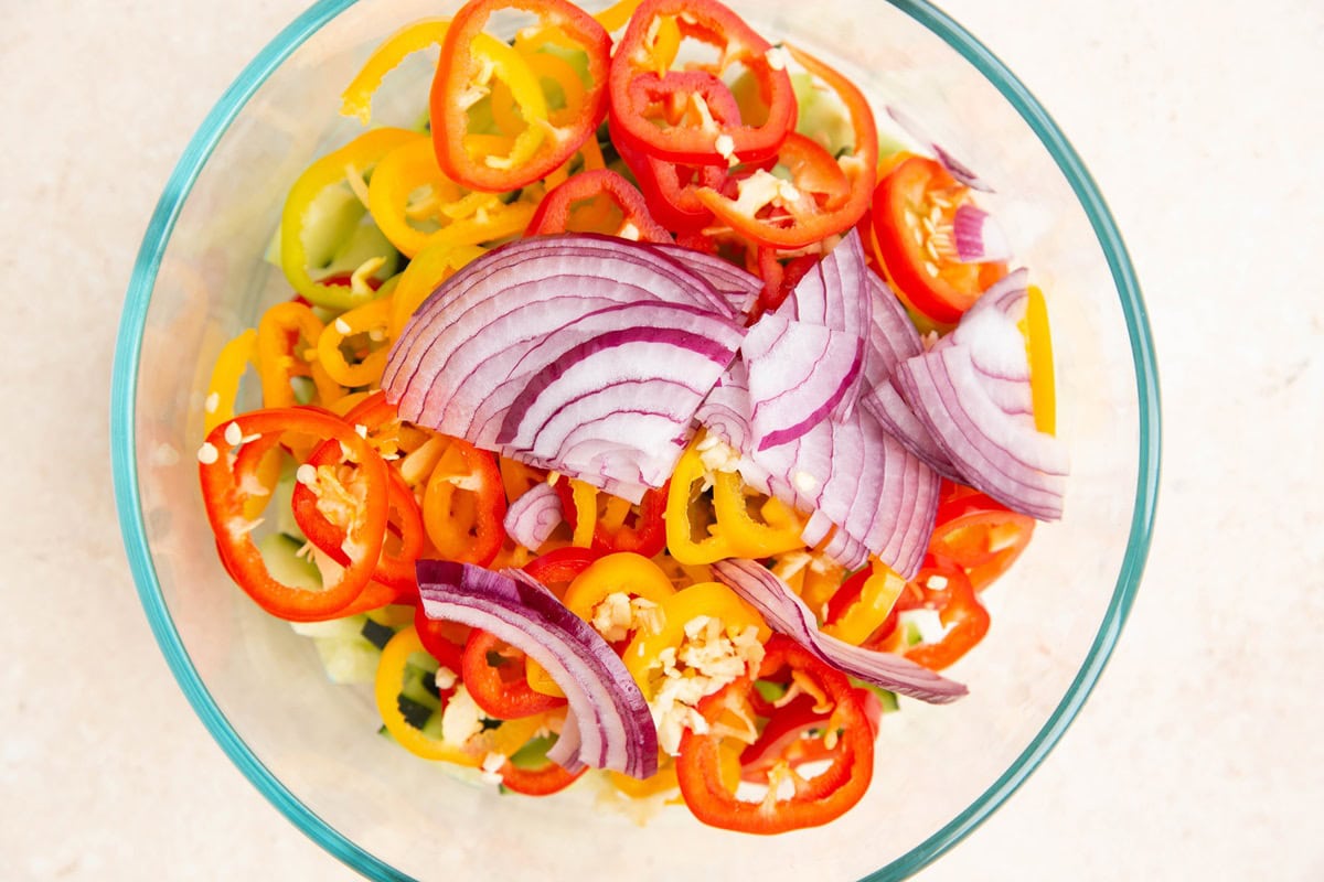 Fresh vegetables in a glass bowl chopped up to make quick pickles.