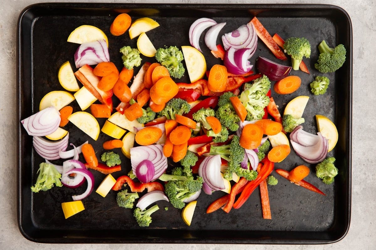 Fresh vegetables spread over a baking sheet.