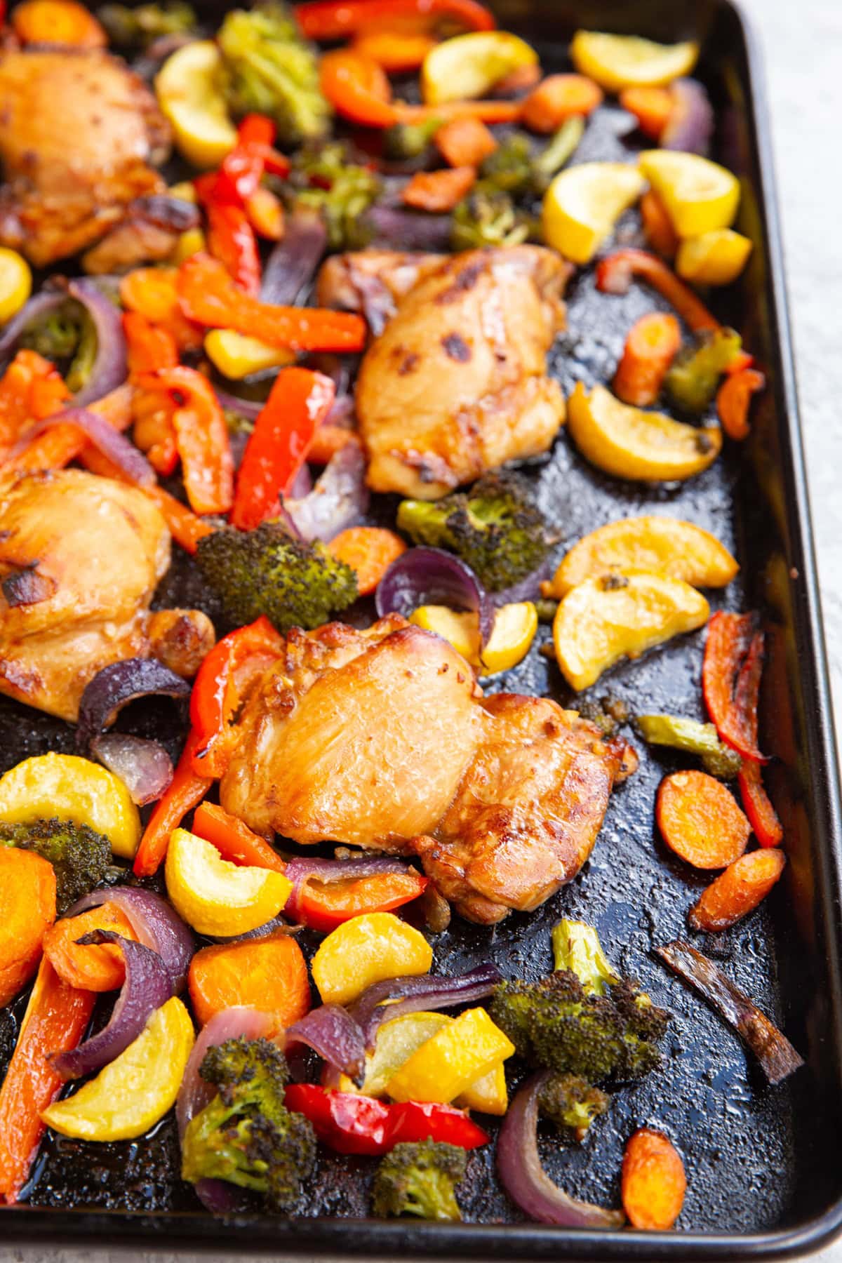 Chicken and vegetables on a large sheet pan.