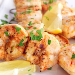 Shrimp skewers sprinkled with fresh parsley, ready to eat.