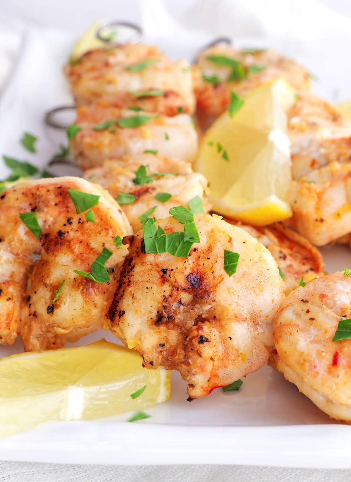 Shrimp skewers sprinkled with fresh parsley, ready to eat.