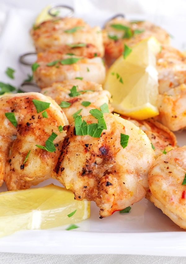 Grilled shrimp skewers on a plate with lemon slices