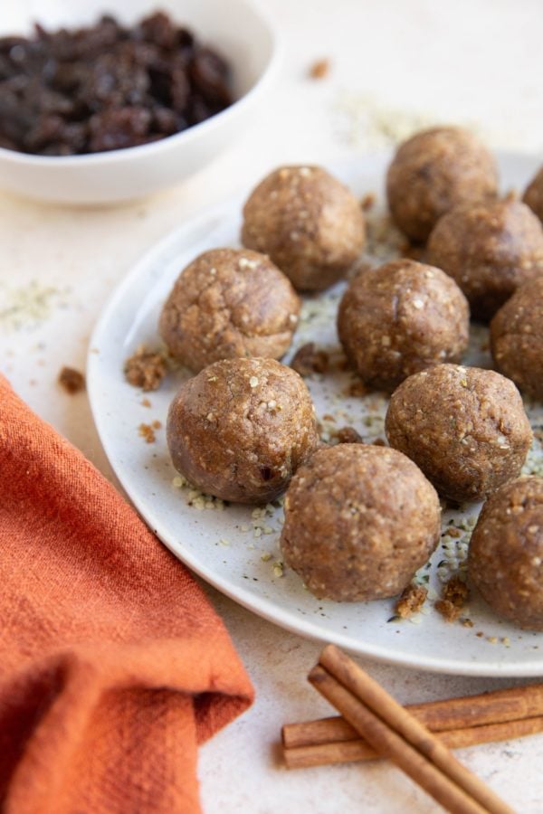 Plate of energy balls with a red napkin and cinnamon sticks to the side.