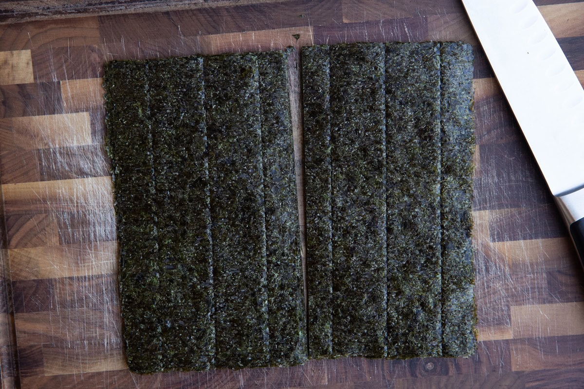 Seaweed papers cut in half on a cutting board.