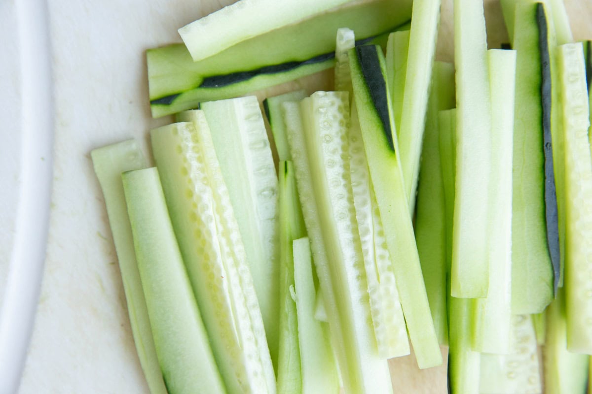 Cucumber slices on a cutting board.