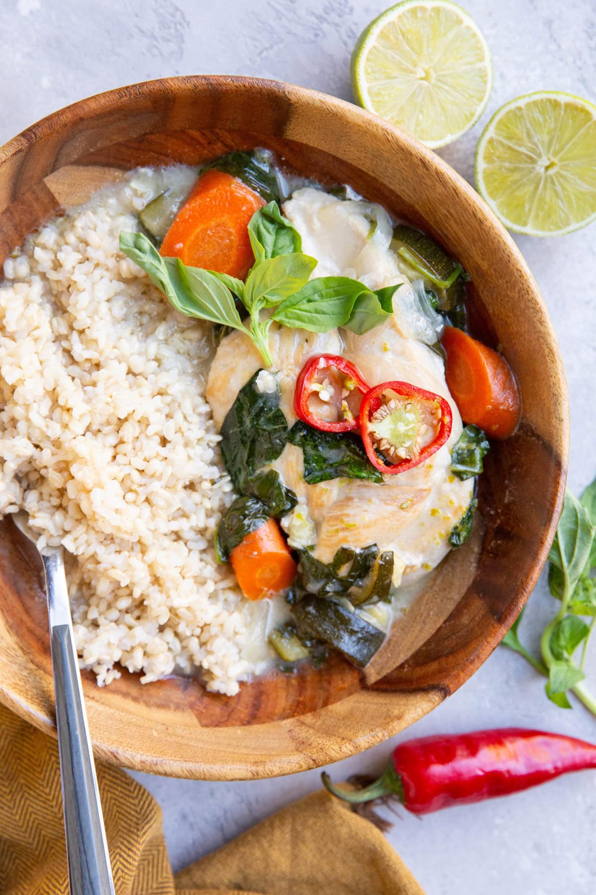 Big wooden bowl of coconut lime chicken and brown rice, ready to eat.