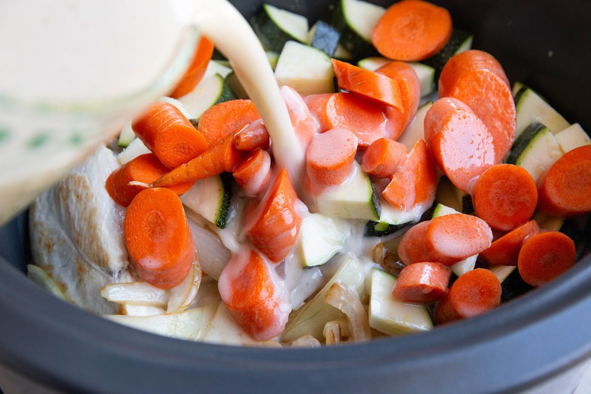 Pouring coconut lime sauce into the crock pot.