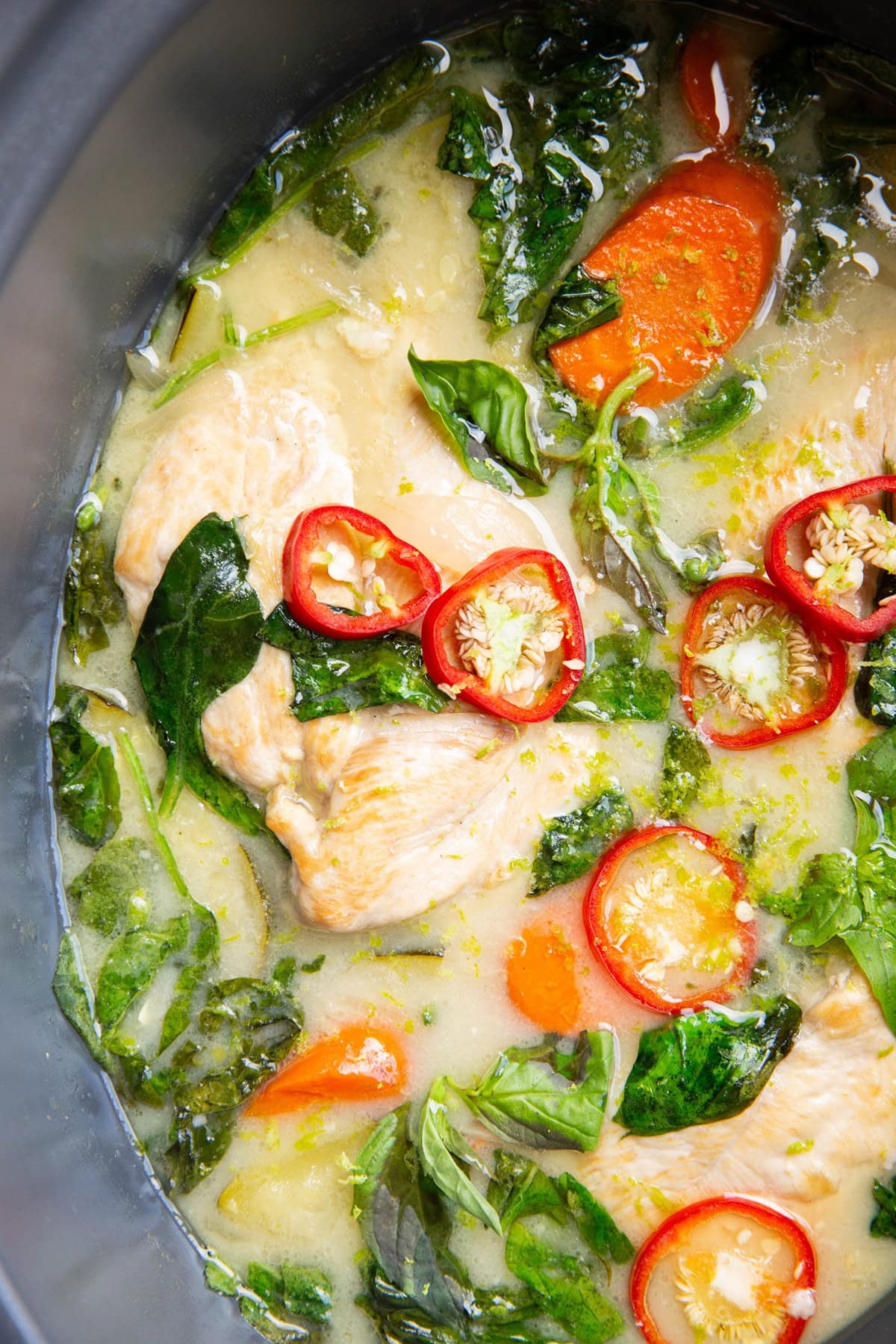 Slow cooker full of chicken breasts in a coconut milk lime sauce.