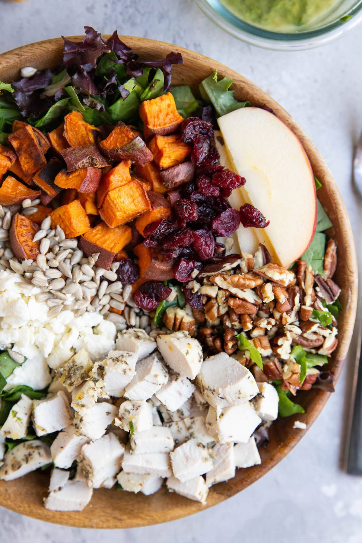 Wooden bowl of salad with a fork to the side.