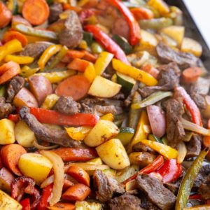 Sheet pan full of cooked steak and vegetables, fresh out of the oven and ready to serve.