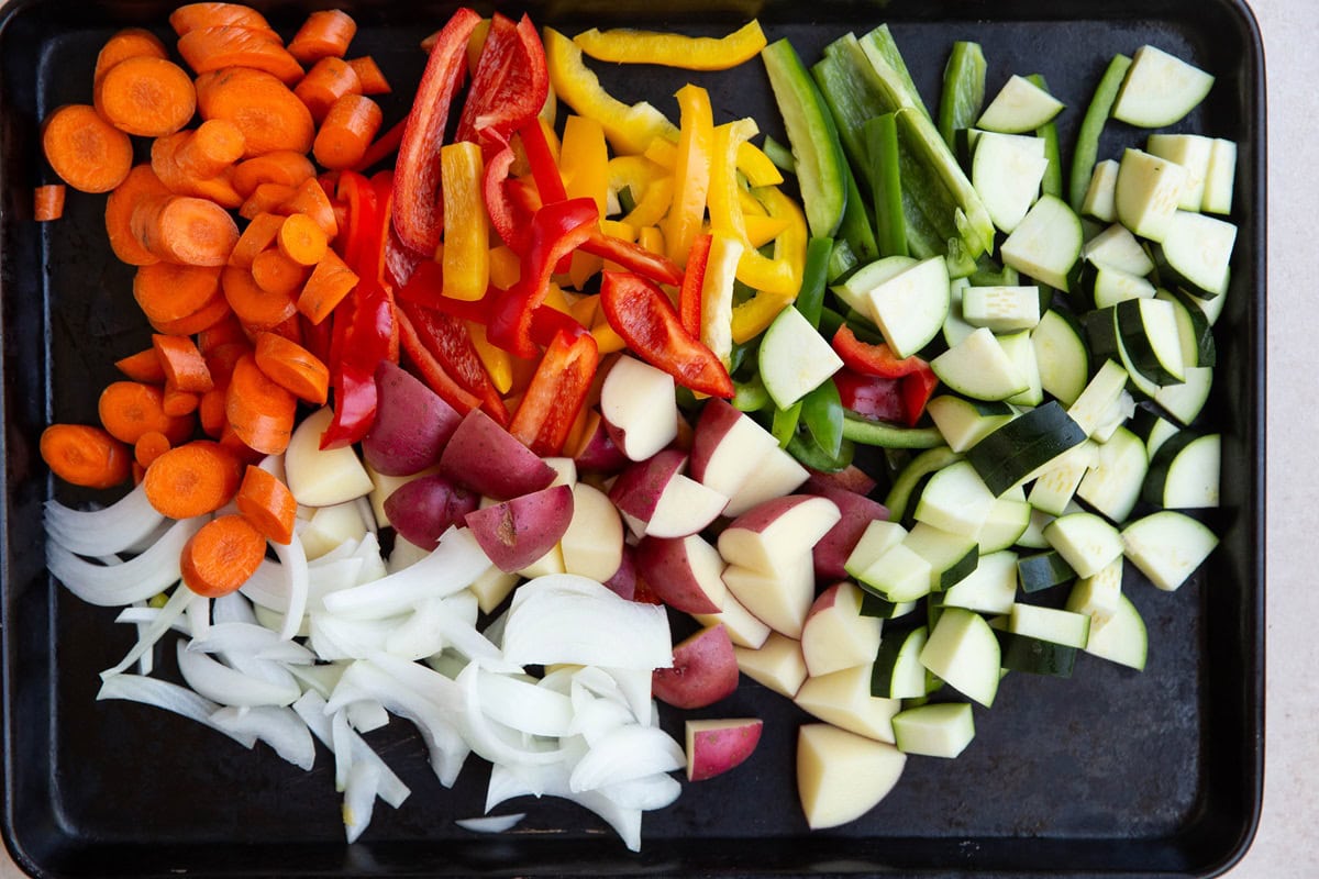 Baking sheet full of chopped vegetables.