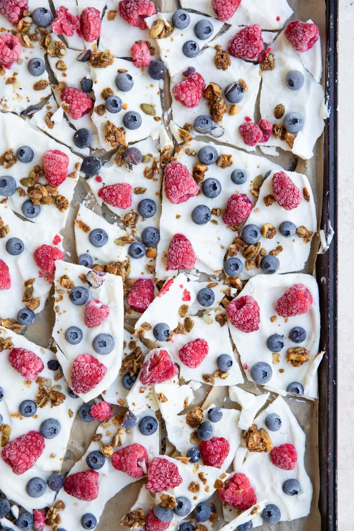 Baking sheet with yogurt bark broken into individual pieces.