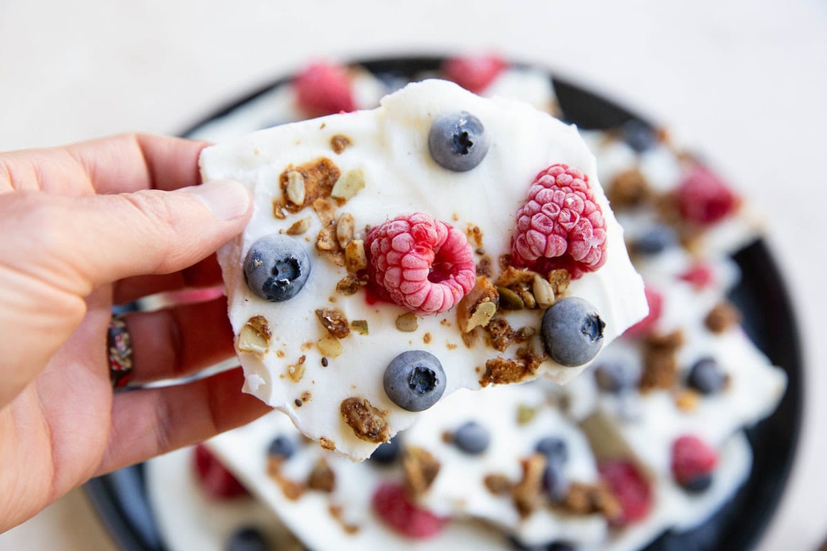 Hand holding a piece of yogurt bark.