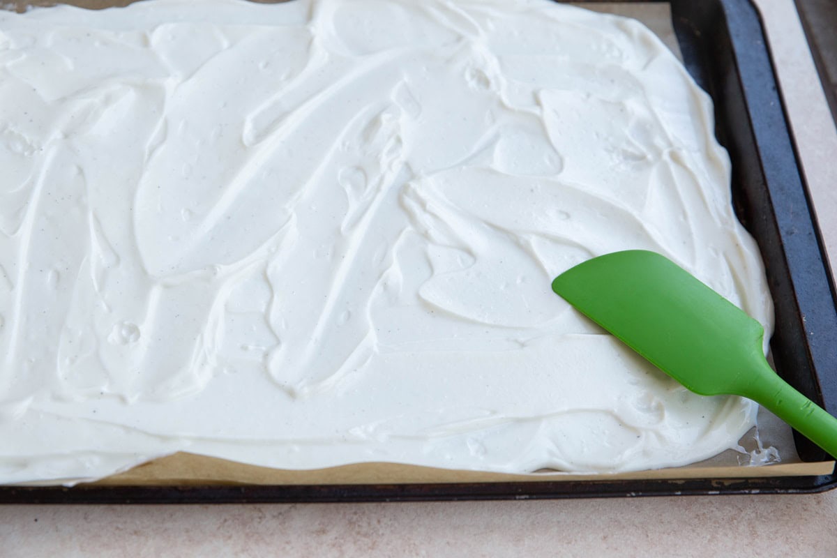 Greek yogurt spread over a baking sheet lined in parchment paper.