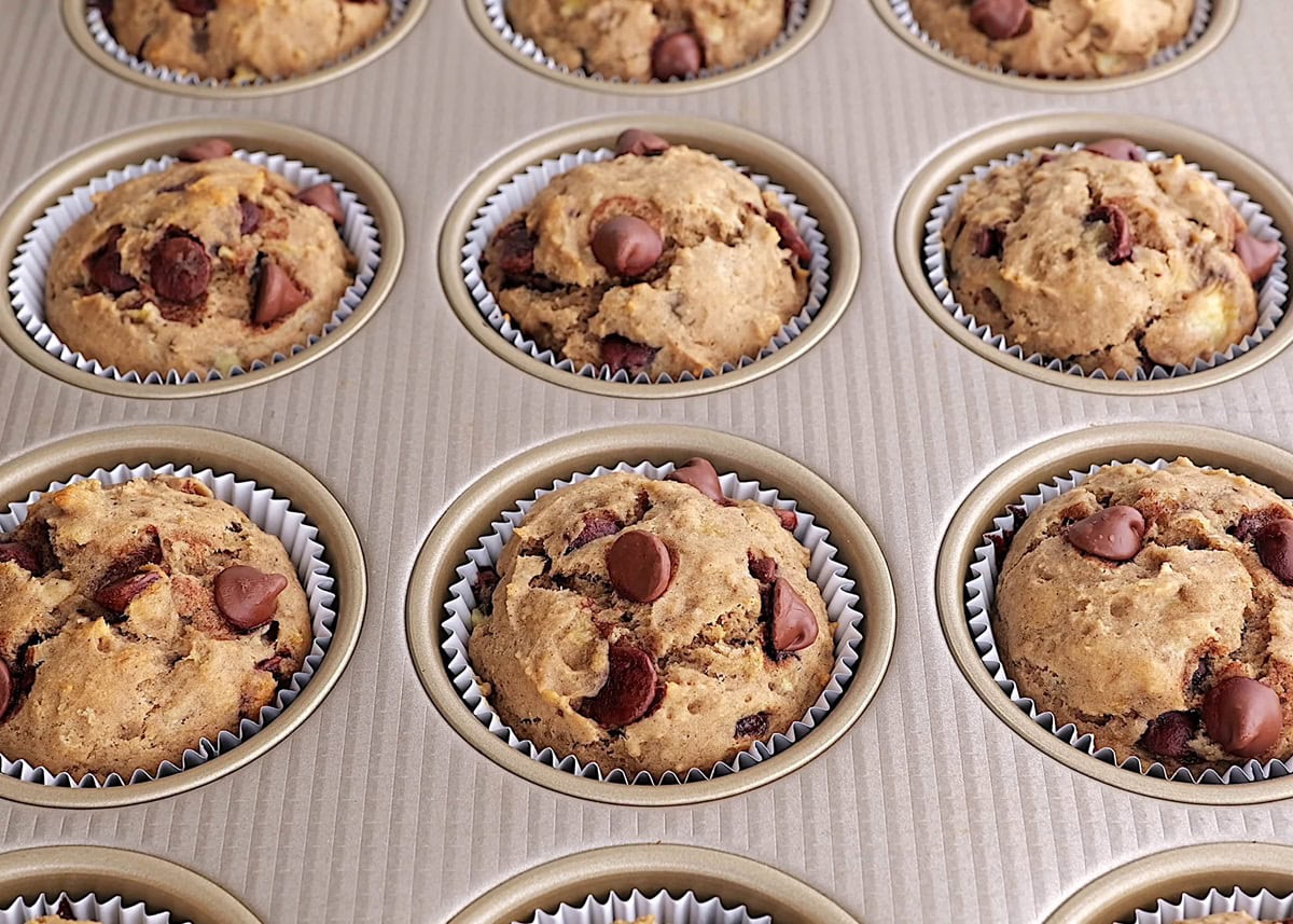 Banana muffins with chocolate chips in a muffin tray fresh out of the oven.