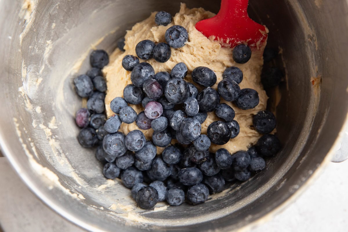 Blueberries on top of coffee cake batter, ready to be folded into the batter.