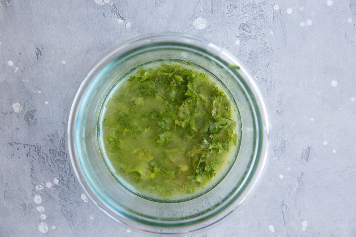 Lemon parsley dressing in a small bowl.