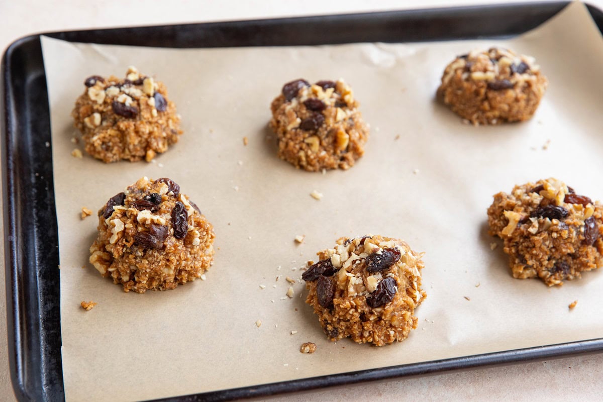 Mounds of cookie dough on a parchment-lined baking sheet.