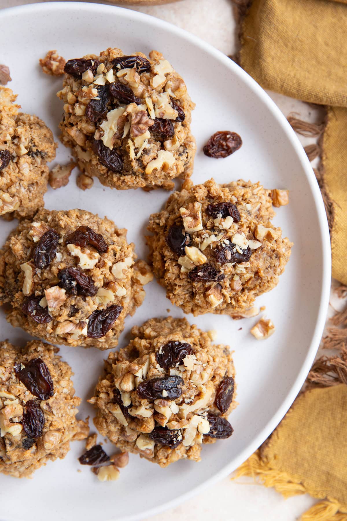 White plate full of peanut butter oatmeal raisin cookies.