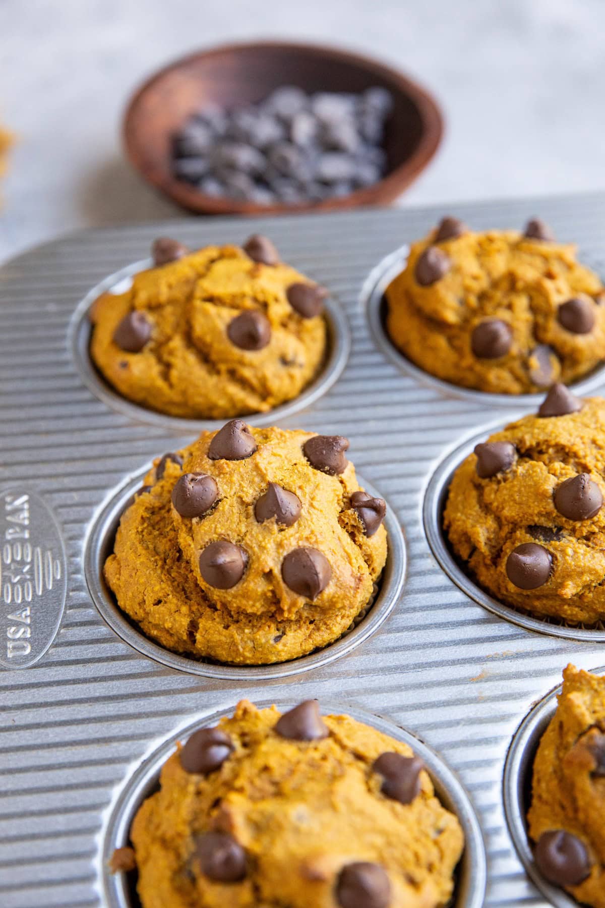 Muffin tin with pumpkin muffins fresh out of the oven.