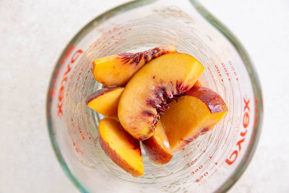 Peach pie filling mixture in a measuring cup.