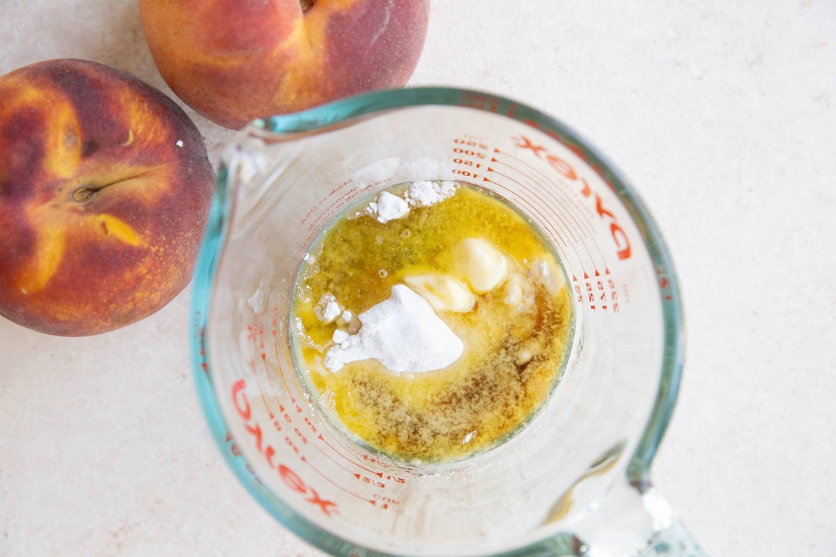 Ingredients for peach cobbler topping in a measuring cup.