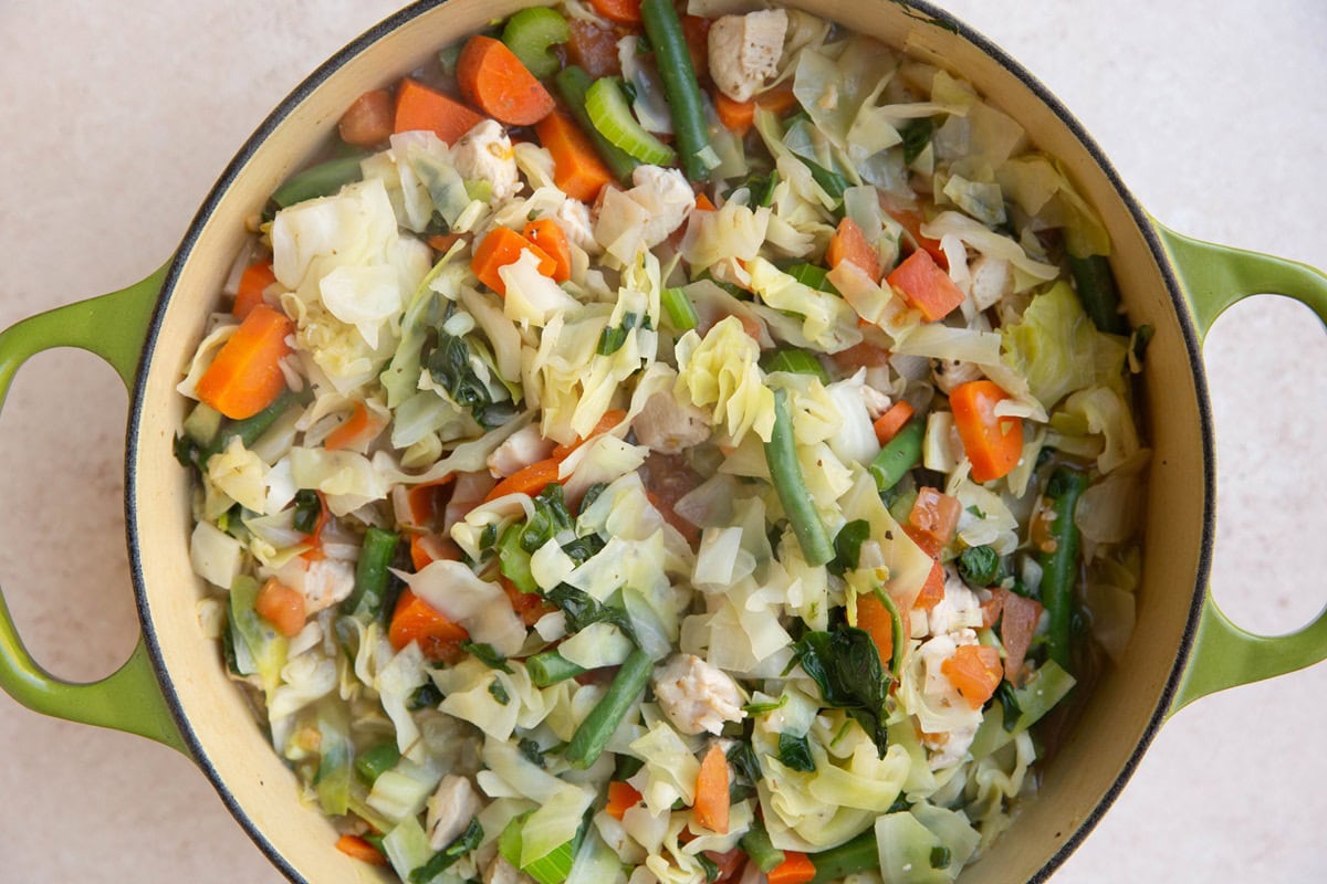 Big pot of vegetables with chicken to make chicken cabbage soup.