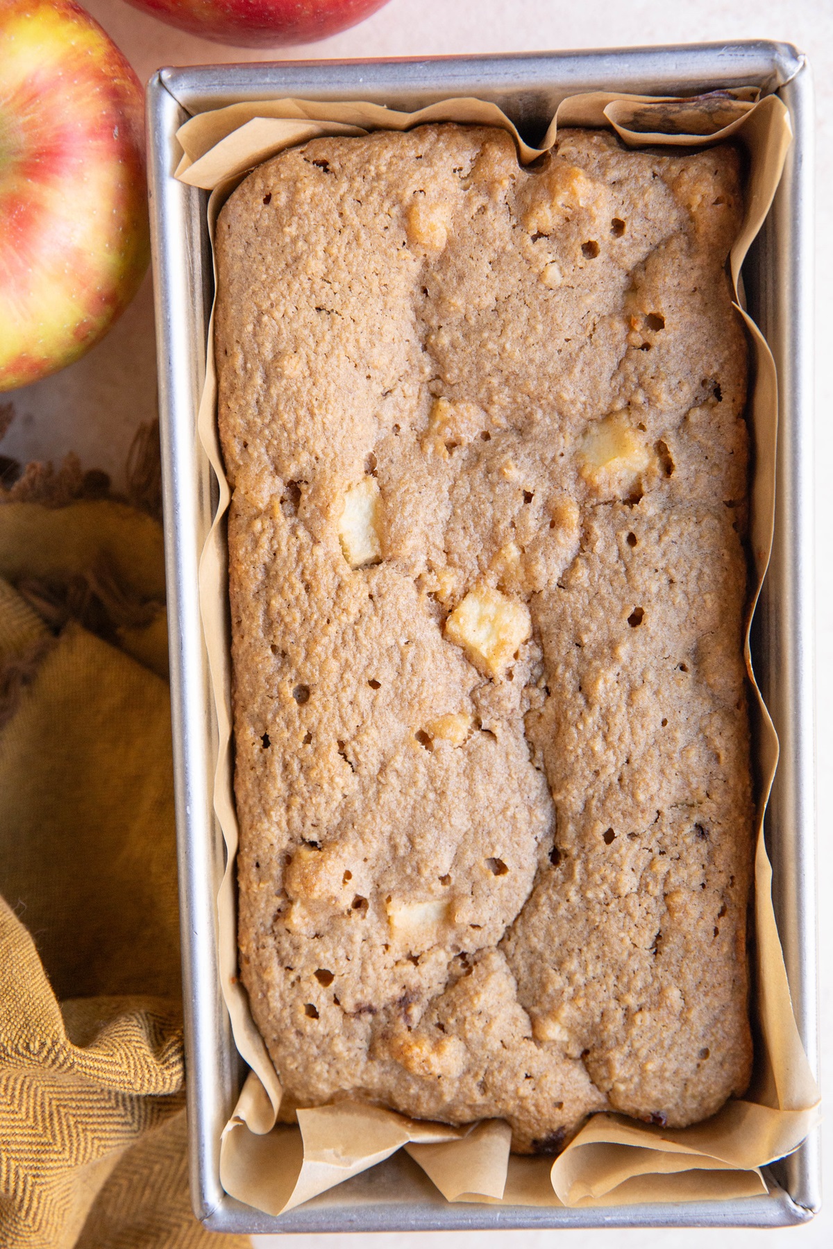 Loaf pan with apple bread inside, fresh out of the oven and ready to slice.