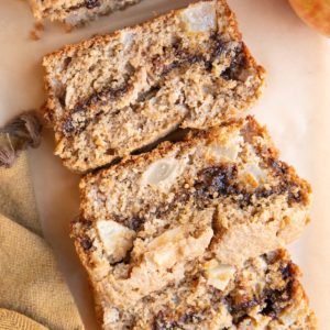 Loaf of cinnamon swirl apple bread cut into slices.