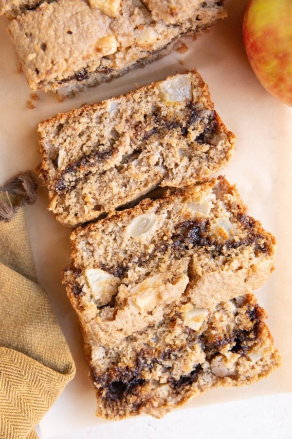 Loaf of cinnamon swirl apple bread cut into slices.