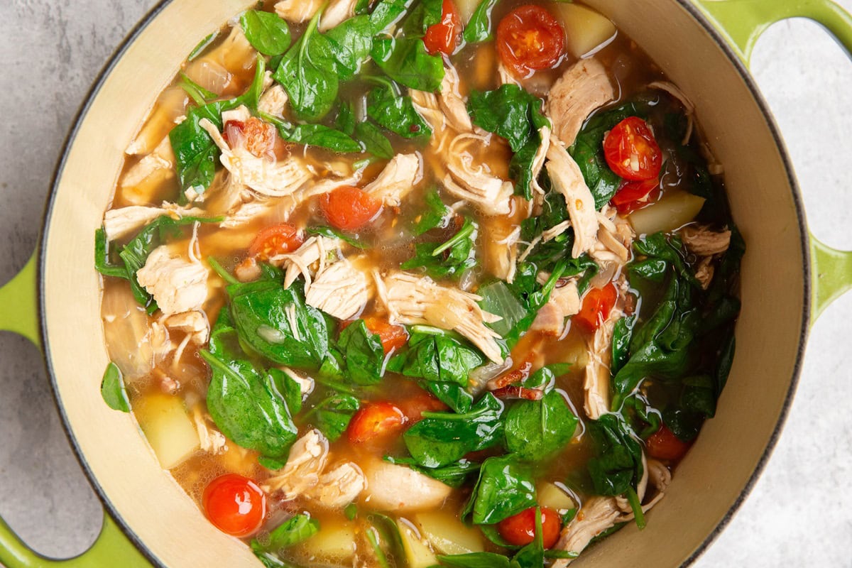 Chicken and vegetable soup in a large pot.