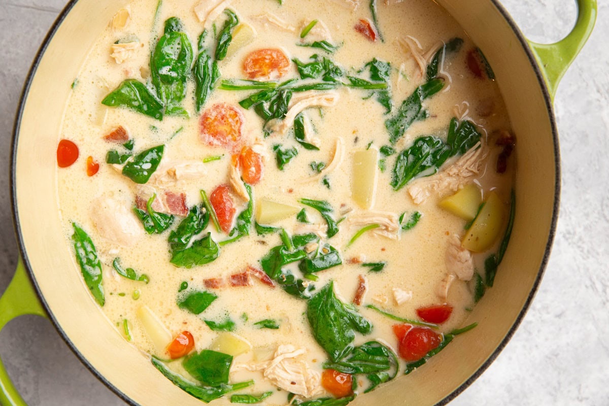 Large pot of soup with creamy chicken and vegetables.