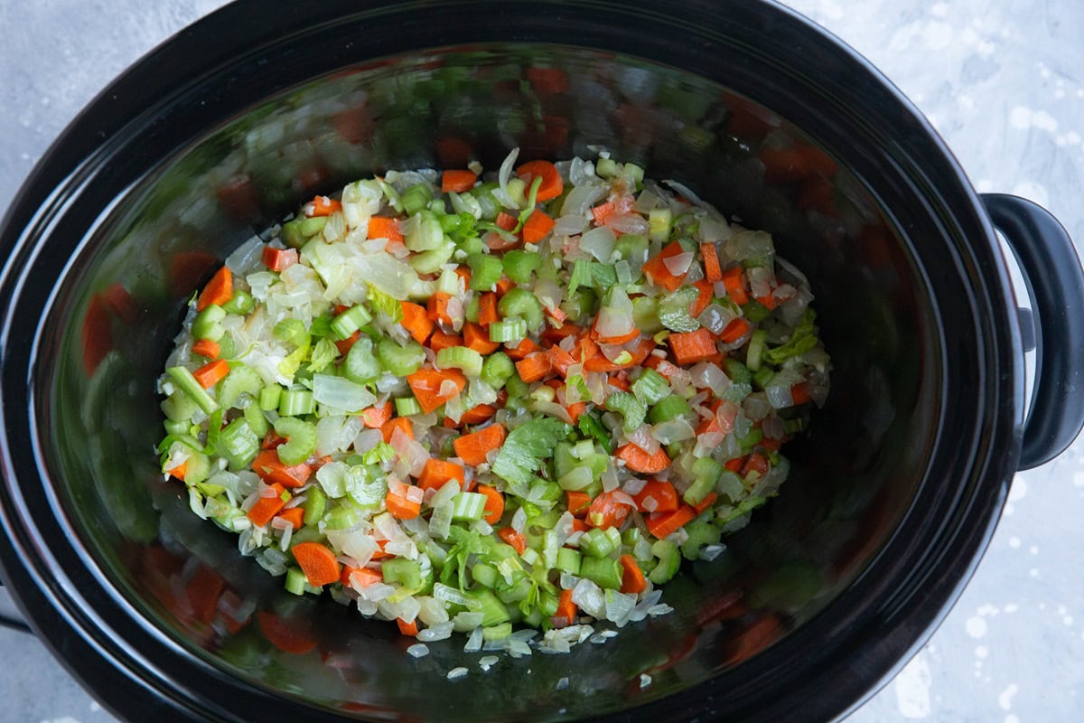 Crock pot full of onion, celery, and carrots.