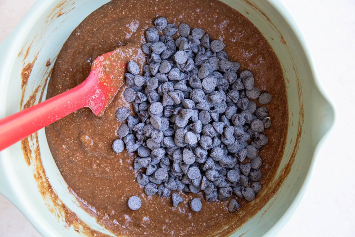 Mixing bowl of muffin batter with chocolate chips inside