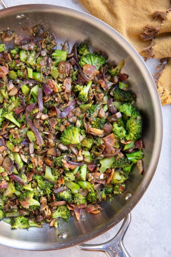 Stainless steel skillet full of sauteed broccoli and mushrooms, ready to eat.