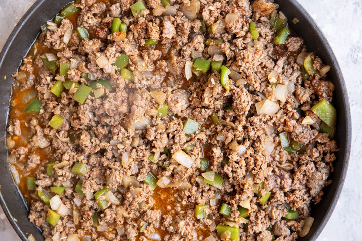 Ground beef, onion, and bell pepper cooking in a skillet