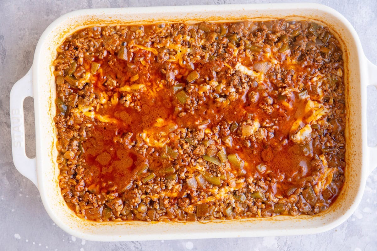 Enchilada casserole in a baking dish, mostly finished.