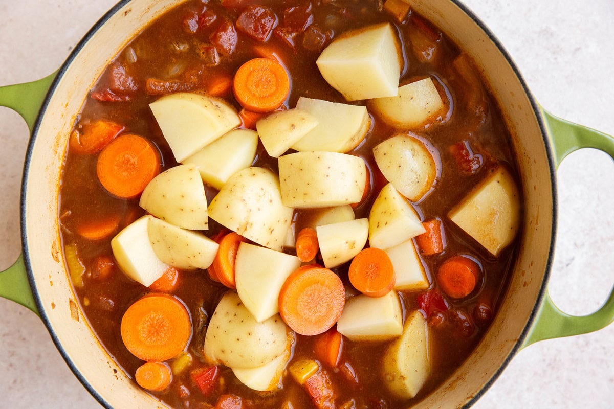 Big pot of beef and vegetables with potatoes and carrots added in.