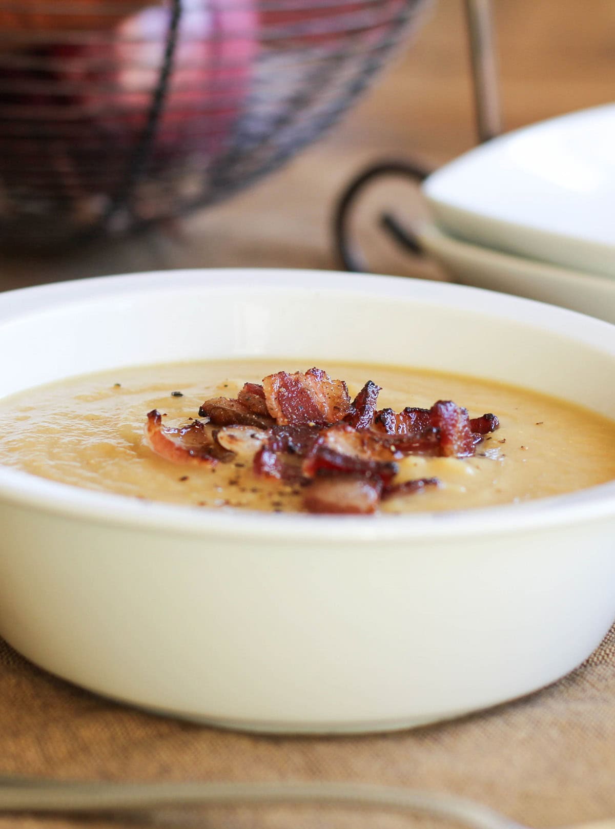 Bowl of potato leek soup with crispy bacon on top