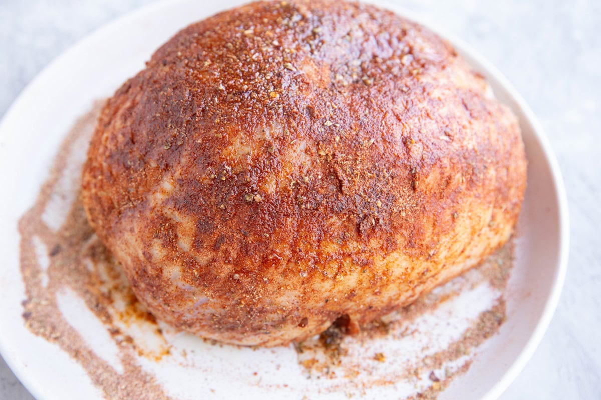 Boneless turkey breast covered with spices, ready to go into a slow cooker.