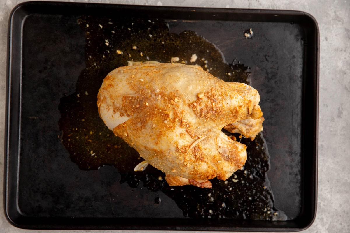 Bone-in turkey breast on a rimmed baking sheet, ready to go into the oven.