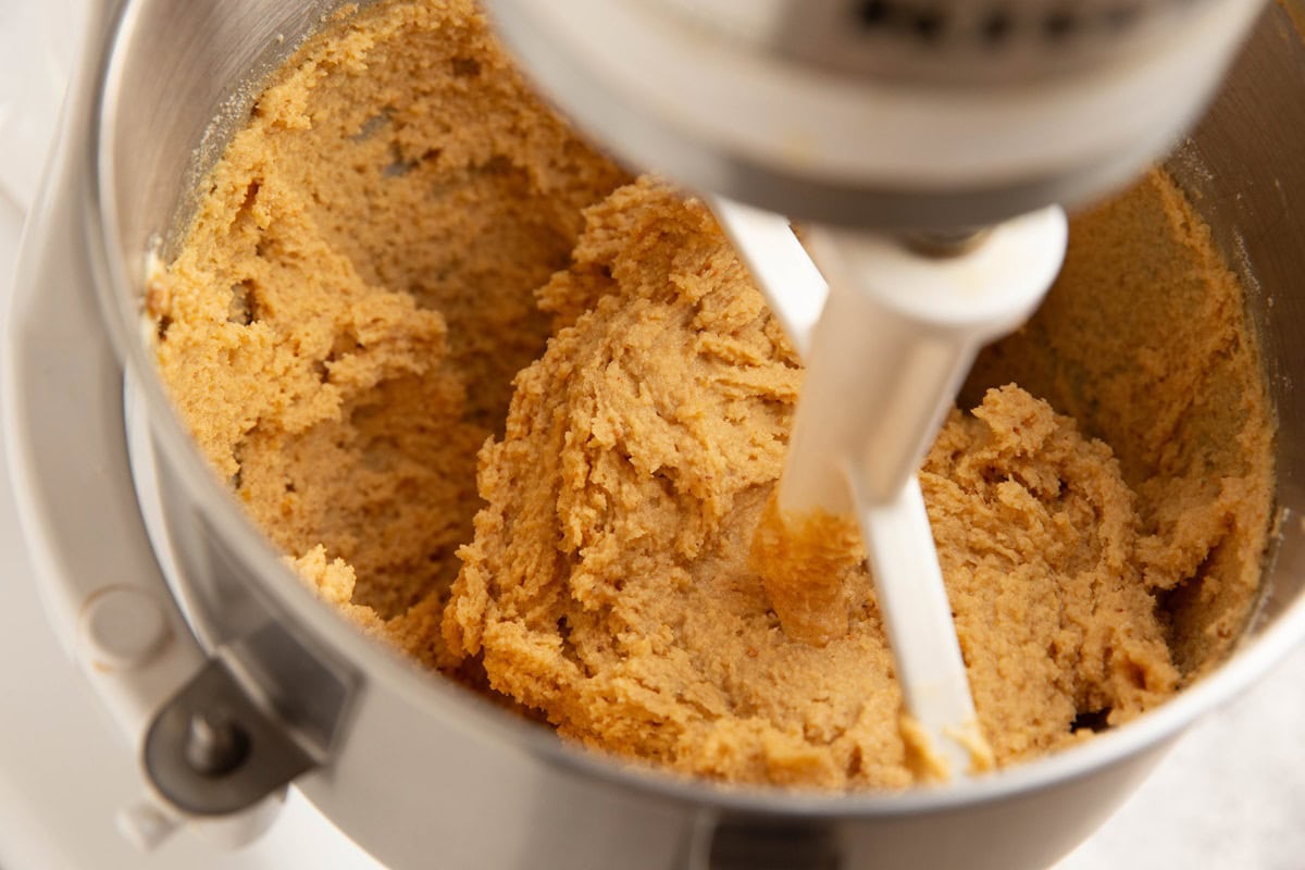 Peanut butter cookie dough in a stand mixer, ready to be baked.