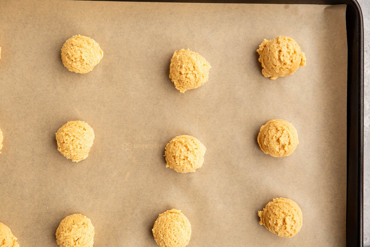 Baking sheet with peanut butter dough balls on top